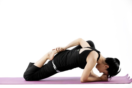 Asian female practising yoga on a matの写真素材