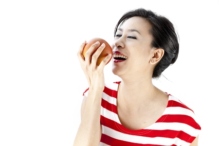 Close up of woman in red stripes dress posing with a fruitの写真素材