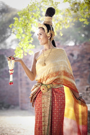 Asian woman dressed in traditional Thai clothing posingの写真素材