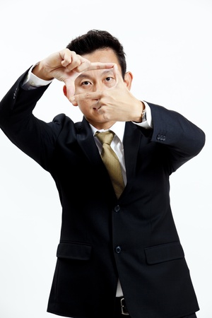 Businessman posing with finger frame isolated on white backgroundの写真素材