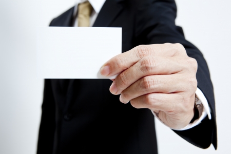 Businessman holding a blank business card isolated on white backgroundの写真素材