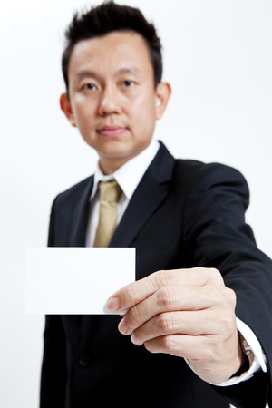 Businessman holding a blank business card isolated on white backgroundの写真素材