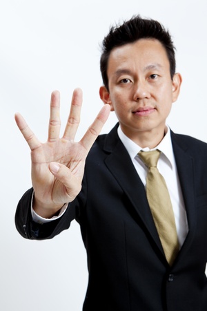 Businessman showing four fingers isolated on white backgroundの写真素材