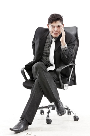 Close-up of businessman sitting on chair against white backgroundの写真素材