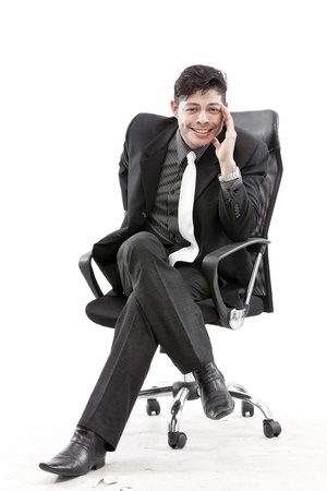 Close-up of businessman sitting on chair against white backgroundの写真素材