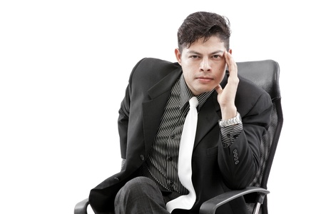 Close-up of businessman sitting on chair against white backgroundの写真素材