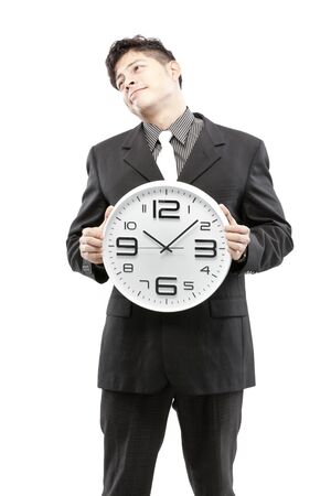 A young businessman with analog clock on white backgroundの写真素材