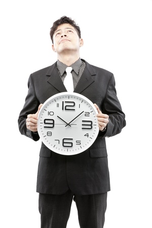 A young businessman with analog clock on white backgroundの写真素材