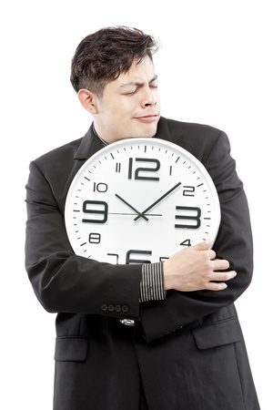 A young businessman with analog clock on white backgroundの写真素材