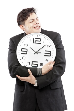 A young businessman with analog clock on white backgroundの写真素材
