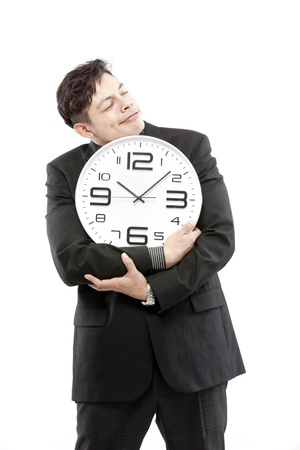 A young businessman with analog clock on white backgroundの写真素材