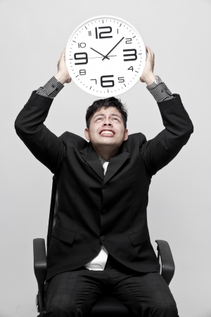 Businessman holding big clock and give the expressionの写真素材