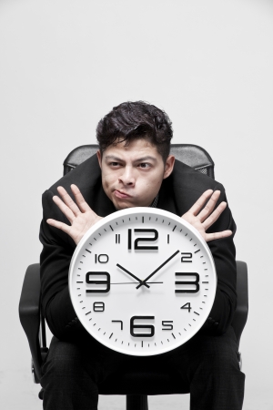 Close-up of a young businessman with analog clockの写真素材