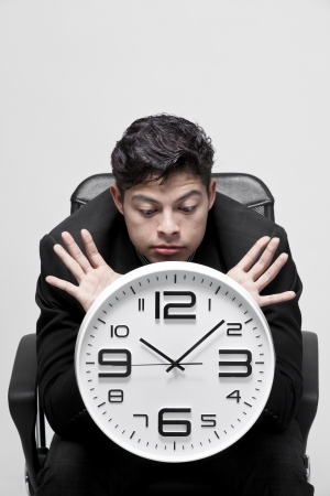 Close-up of a young businessman with analog clockの写真素材