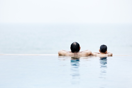 An adult and a young boy in a swimming pool togetherの写真素材