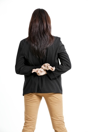 Young business woman with her fingers crossed behind her back isolated on white   backgroundの写真素材