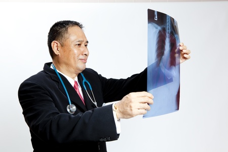 Mature doctor checking X-ray resultsの写真素材
