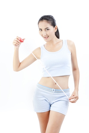 Beautiful asian lady is holding measuring tapeの写真素材