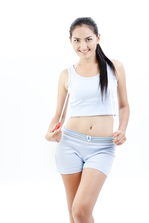 Beautiful asian lady is holding measuring tapeの写真素材