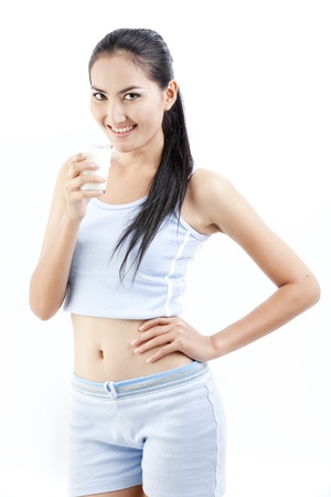 Beautiful asian lady is drinking a cup of milk の写真素材