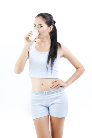 Beautiful asian lady is drinking a cup of milk の写真素材