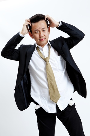 A man holding his head dressed in sloppy work attireの写真素材