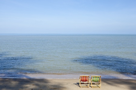 Two deck chairs beside the beach on a sunny dayの写真素材