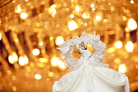 Bride and groom on top of a wedding cakeの写真素材