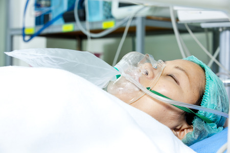Patient with oxygen mask lying on a gurneyの写真素材