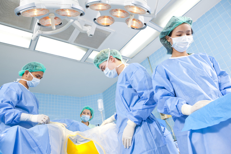 Surgeons and nurses in an operating roomの写真素材