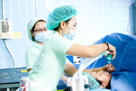Nurses adjusting oxygen tube of a patientの写真素材