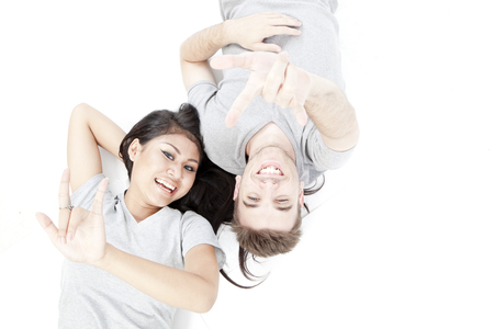 Lovely couple is lying down isolated on white backgroundの写真素材