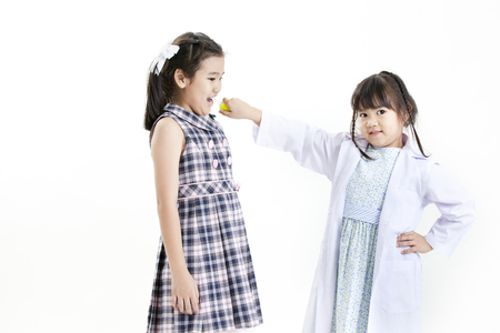 Two girls playing the roles of doctor and patientの写真素材