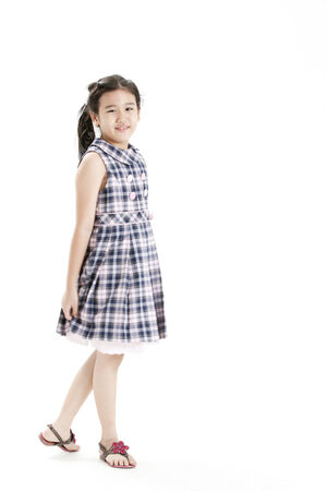 Girl posing in a checkered dress while holding skirtの写真素材