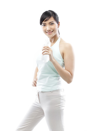 Young woman holding a water bottle and posing for the cameraの写真素材