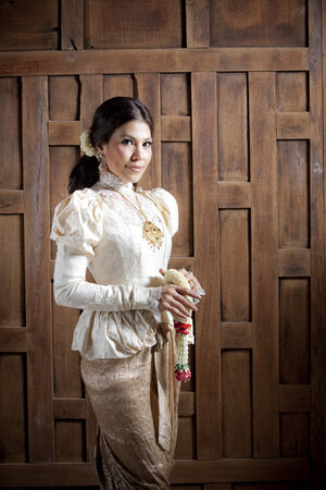 Woman in traditional clothes standing while holding flower garlandの写真素材