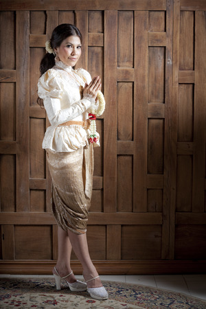 Woman in traditional clothes standing while holding flower garlandの写真素材