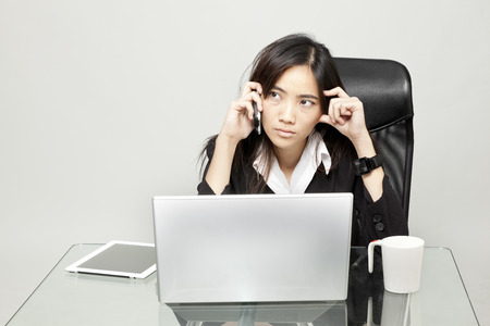 Businesswoman talking on mobile phone and looking awayの写真素材