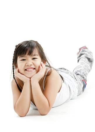 Girl lying on stomach and posing for the cameraの写真素材