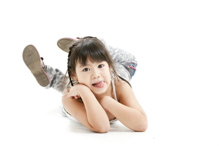 Girl lying on stomach and sticking tongue out