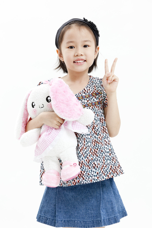 Girl posing in casual clothings while holding a stuff toyの写真素材