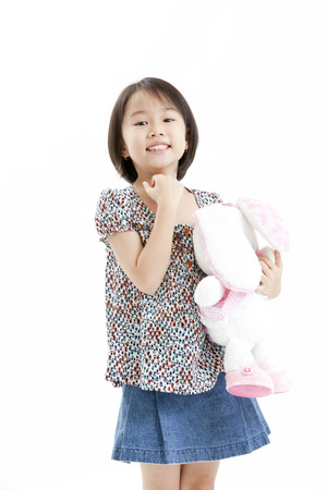 Girl posing in casual clothings while holding a stuff toyの写真素材