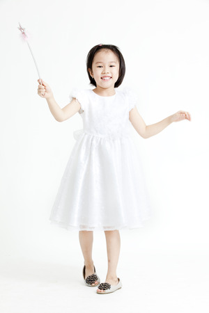 Girl posing in a white dress with a wandの写真素材