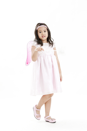 Girl posing as an angel dressed in a white dressの写真素材