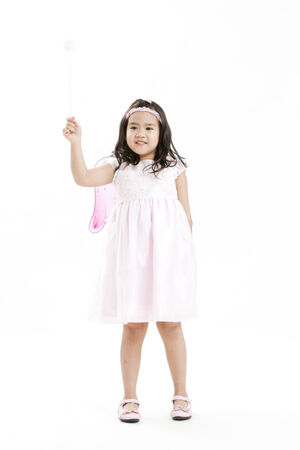 Girl posing as an angel dressed in a white dressの写真素材