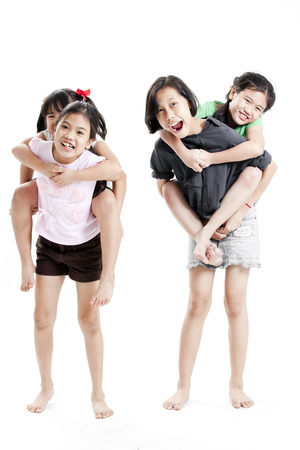 Girls carrying each other on white backgroundの写真素材