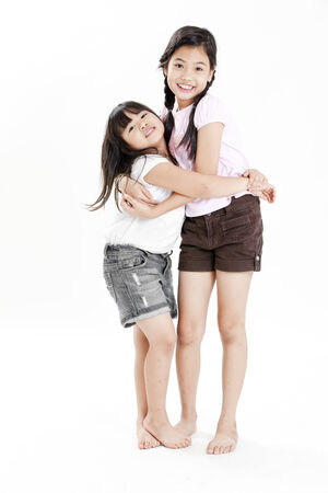 Two girls standing next to each other on white backgroundの写真素材