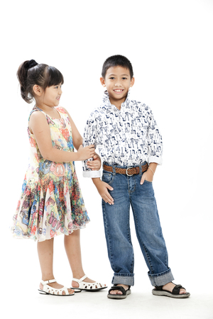 Boy and girl posing in casual attire on white backgroundの写真素材
