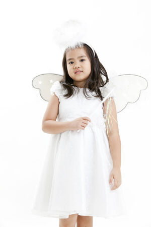 Girl posing as an angel dressed in a white dressの写真素材