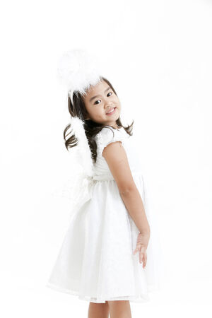 Girl posing as an angel dressed in a white dressの写真素材
